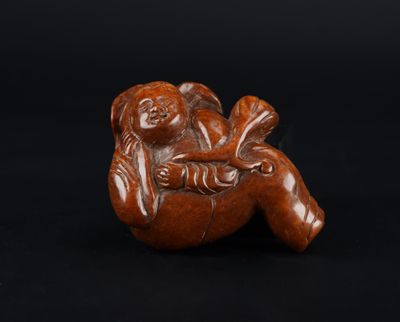 une petite figurine sculptée représentant un singe sur fond noir