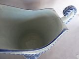 a blue and white gravy shaped bowl with a handle