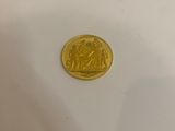 a close up of a gold coin on a white surface