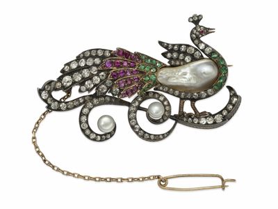 une image représentant une broche ornée d'un paon et de perles