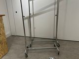 a metal rack with clothes hanging on it in a room