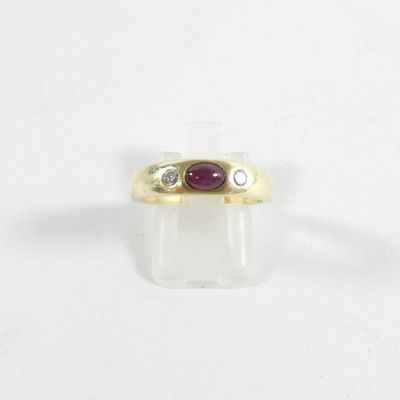 gros plan d'une bague en or avec une pierre en rubis