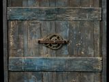 an old wooden door with a rusty latch on it