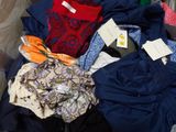 a lot of clothes in a suitcase with tags on them