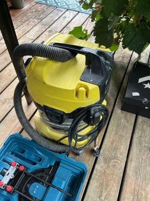 un aspirateur jaune et bleu sur une terrasse en bois