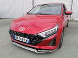 l'avant d'une voiture rouge garée devant un immeuble