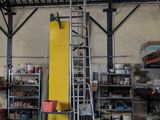 une photo d'un entrepôt avec une échelle au milieu de la pièce