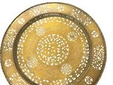 a gold plate with a design on it on a white background