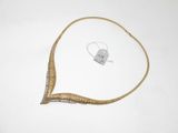 une image représentant un collier en or posé sur une surface blanche