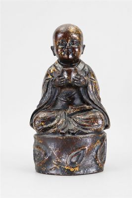 une image représentant une statue d'une personne assise sur un rocher