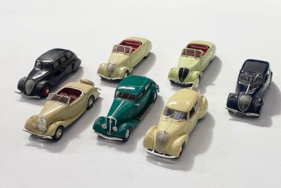 plusieurs petites voitures sont alignées sur une surface blanche
