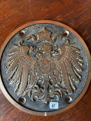an image of a wooden table with a metal plate with an eagle on it