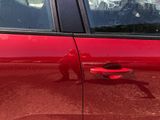 a red car with a red frisbee on the door handle