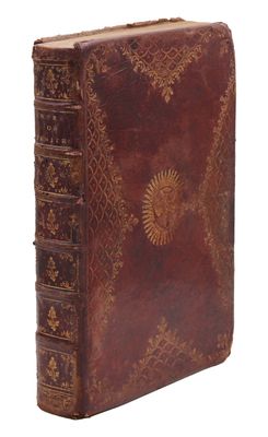un vieux livre à la couverture brune posé sur une surface blanche