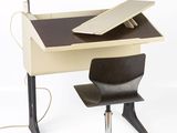 a desk with a chair and a laptop on it