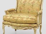 une chaise à l'ancienne dont le dossier est recouvert d'un tissu à motifs floraux