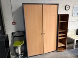 a cabinet and a chair in a room with a clock on the wall