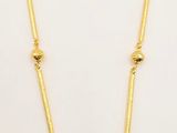 a black and gold necklace with beads on a white background