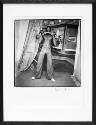 black and white photograph of a man standing in front of a curtain