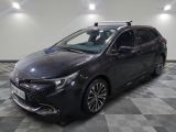 La Toyota Corollant est garée dans un garage dont le sol est en damier.