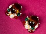 pair of brown and green earrings on a pink surface