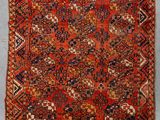 un tapis persan ancien aux motifs rouges, bleus et orange
