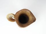 a wooden vase with a horn shaped handle on a white surface