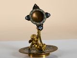 a gold and blue candle holder on a white table
