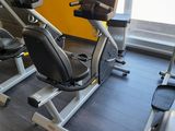 une salle de sport équipée d'une rangée de vélos d'appartement et de tapis de course