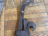 pair of old iron scissors on a wooden floor next to an old pair of scissors