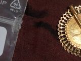 une broche en or et une épingle en or sur un tissu marron