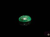 a close up of a green emerald on a black surface