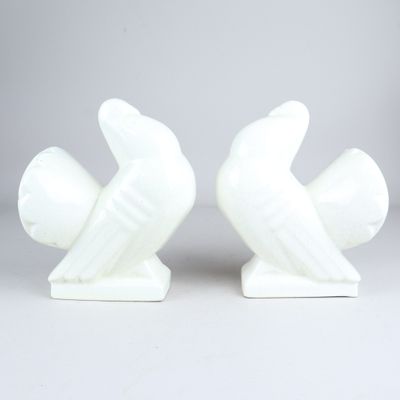 une paire de serre-livres en céramique blanche représentant des oiseaux, sur fond blanc