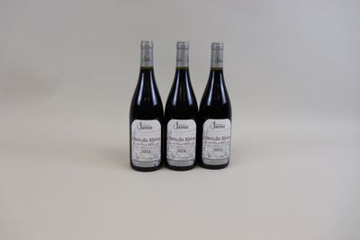 trois bouteilles de vin posées les unes à côté des autres sur une surface blanche