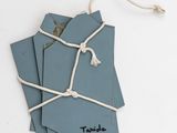 blue tags tied to a string on a white surface