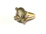 une image représentant une bague ornée d'une grosse pierre grise entourée de diamants
