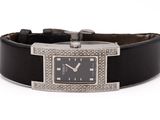 une photo d'une montre-bracelet sertie de diamants, montée sur un bracelet en cuir noir