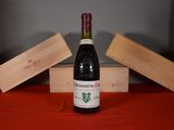 a bottle of wine sitting on a table next to two wooden boxes