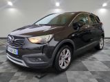 une Opel noire garée sur un sol à damier dans un garage