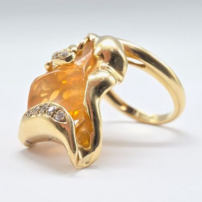 une image représentant une bague en or sertie d'une pierre orange et de diamants