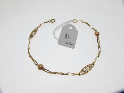 un bracelet en chaîne d'or auquel est attachée une plaque