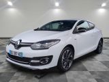 une voiture blanche est garée dans une pièce au sol à carreaux