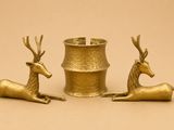 deux figurines de cerfs en or posées l'une à côté de l'autre sur une table