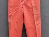 un pantalon orange suspendu à une corde à linge