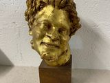statue of a man ' s head on a wooden base