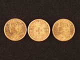 three different types of gold coins on a black background