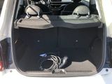the back of a white car with the trunk open and a bunch of electronics in the trunk
