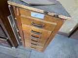 a wooden cabinet that has a drawer on top of it