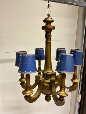 un lustre en or auquel sont suspendues des lampes bleues