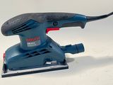 a bosch orbital sander on a white surface